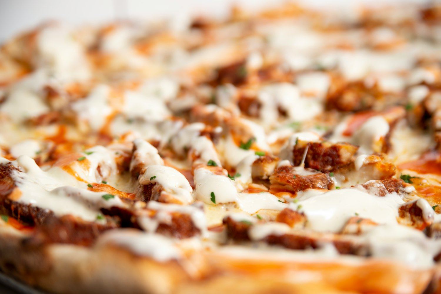 Close-up of a pie topped with breaded chicken and creamy dressing